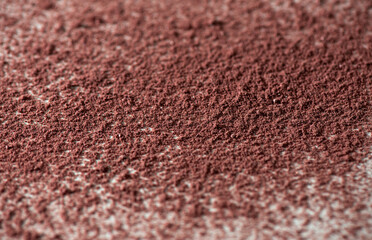 Loosed dry cosmetic pink background pigment. Top view of cracked blush, bronzer, powder or eye shadow cosmetic products. White background, selective focus