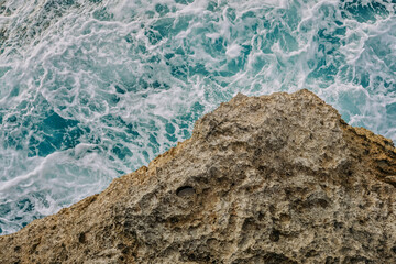 Top view of mountain and sea with splashing waves