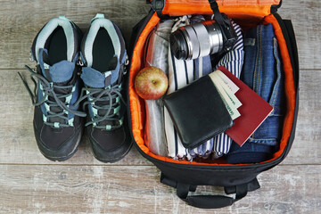 travel backpack with jeans t shirt wallet passport shoes and camera top view