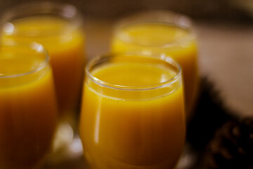 Four glasses of orange juice are on a tray
