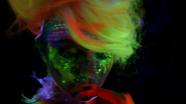 sexually and creative image with fluorescent paints on female skin, woman in uv light