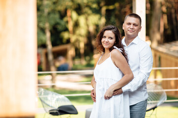 Obraz premium Portrait of cheerful woman and man spending time together and sitting outdoors, hugging and laughing on summer terrace, couple in love on valentine's day togetherness. valentines day