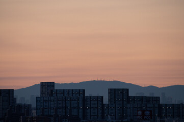 兵庫県神戸市東灘区のマンション高層階から撮影した日の出。梅雨明け後、まだ雲が残るが、オレンジ色に染まりドラマチックな都会の朝。