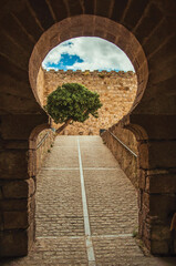 Gateway in typically Moorish style with a cobblestone ramp leading to a courtyard in the Castle of Trujillo. A small medieval town in Spain.