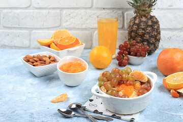Healthy breakfast, fruit salad with grapes, tangerines, banana and slimming jam. The concept of...