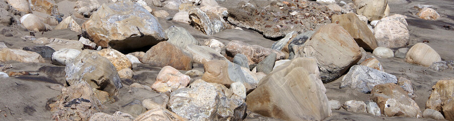 Rocks left over from beach sand erosion after a high wind ocean surf