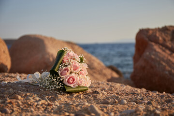 Beautiful bridal bouquet of roses on rocks 
