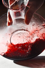 decanter with red wine in the hand of a sommelier