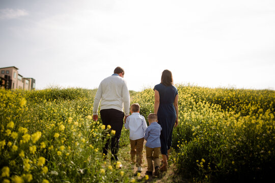 Family of Four Walking Through Wildflower Field