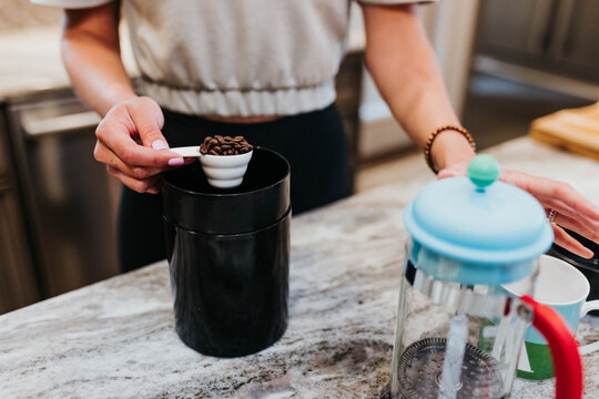 Close up of woman measuring coffee beans in her kitchen