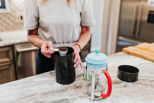 Close up of woman measuring coffee beans in her kitchen