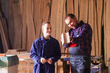 Obraz na płótnie Canvas Young apprentice learning to work at carpentry shop