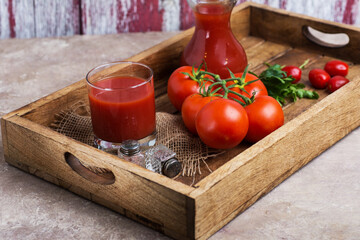 fresh tomato juice and tomatoes on a wooden tray