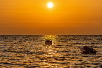 Utjeha, Montenegro - July 07, 2021: A boat at sunrise on the Adriatic Sea