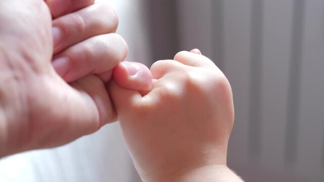 Caucasian Father and Child Making Pinky Swear Promise Gesture with Fingers