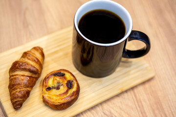 Filter coffee, croissant and cookie on a wooden table