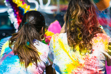 Two Women's Backs and Hair Covered in Colored Powder at a Local Indian Holi Event