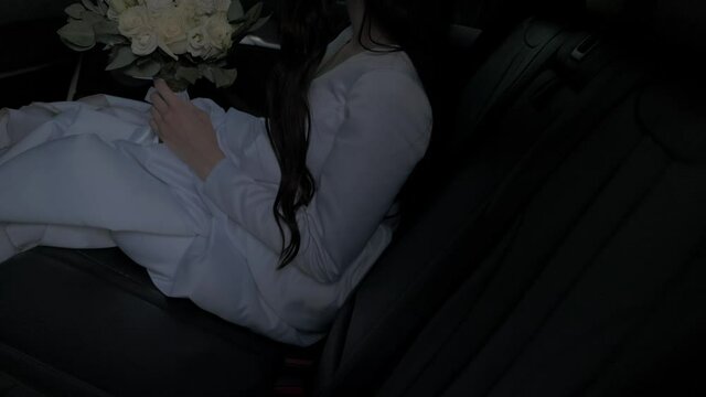 the bride gets into the car from behind