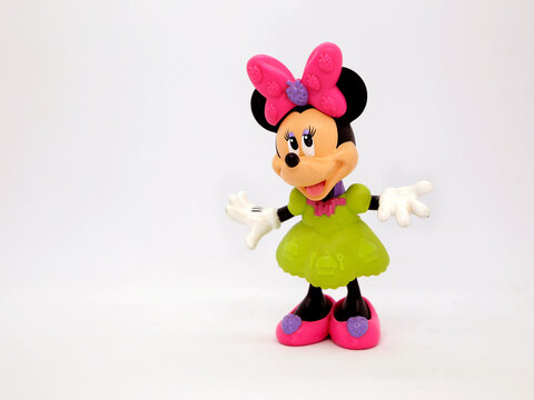 Minnie Mouse. Toy. Cartoon characters from Walt Disney Pictures Studios. Minnie is Mickey Mouse's girlfriend. Green dress. Doll with interchangeable clothes. Isolated white. Plastic toy.