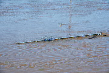 Flood water in fields, Netherlands countryside, 2021. Climate change, extreme weather, global warming. Global floods risk under climate change. Flooded wooden filed gate