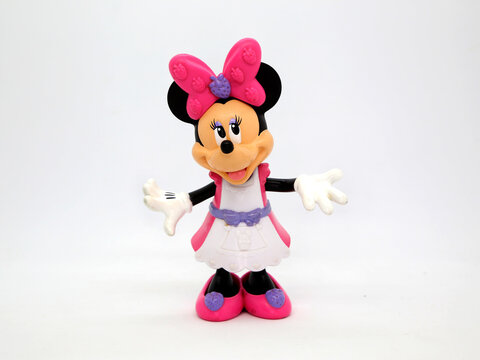 Minnie Mouse. Toy. Cartoon characters from Walt Disney Pictures Studios. Minnie is Mickey Mouse's girlfriend. Pink and white dress. Doll with interchangeable clothes. Isolated white. Plastic toy.