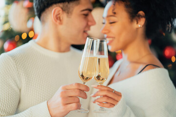 Happy young couple husband and wife. Celebrate the New Year and Christmas online. They drink dry white wine champagne in glasses.