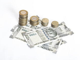 High angle shot of stacks of Indian rupee coins on top of bills on a white isolated background © Arun Kumar/Wirestock