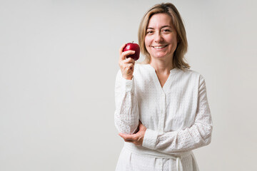 Older woman in her 50s eating an apple