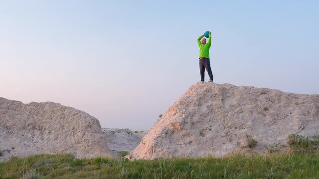 sunrise workout with a heavy slam ball - is exercising at a cliff in Pawnee National Grassland in Colorado
