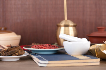 The medicine mortar and a plate of wolfberry on the medicine book
