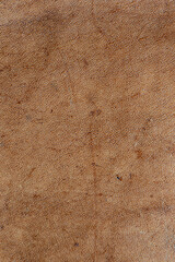 leather grunge background: an old piece of tough camel skin, with scuffs, spots, scars