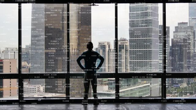 4k businessman back raising victory arm;Overlooking the urban from window.Rolling business data;Digital Tableau of Stock Market Values.
