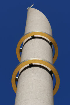 minaret of the mosque of cologne with the two golden rings in front of a dark blue sky