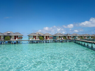 Villas on stilts (bungalows) surrounded by beautiful clear turquoise water of Indian Ocean. Resort...