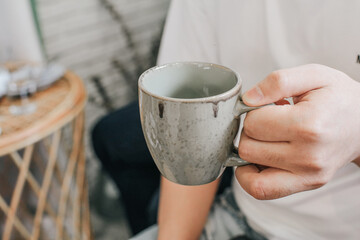 Man holding a ceramic cup of water. Cup of purified water holding in hand. Man drinking healthy beverage.