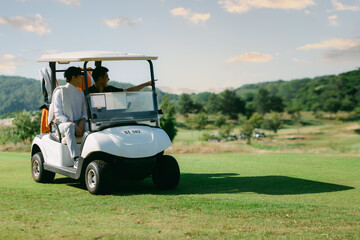 Golf carts with Golfers happily driving on the green lawn.