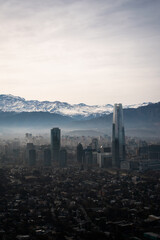 A view of Santiago, Chile, from the mountains, with the snowy mountains behind and the skyline