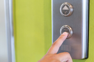 Women fingers pressing buttons  to call the elevator