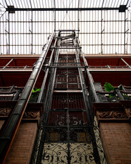 interesting architecture of elevator inside of a train station filled with natural light
