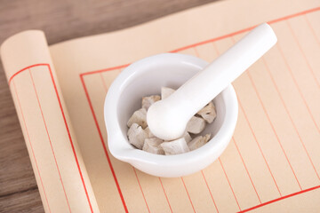 The white medicinal mortar with Pueraria lobata root on the blank notebook