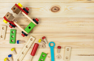 Fototapeta na wymiar A colorful wooden building kit for children on wood. Set of tools on wooden table. Games and tools for kids in preschool or daycare. Natural, eco-friendly toys.