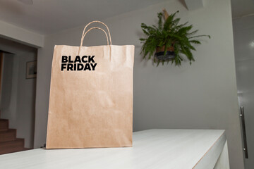 Black Friday cardboard bag on the table brown paper packaging with personalized writing and living...
