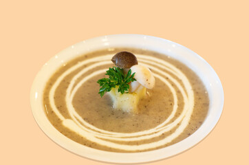 Mushroom cream soup in the bowl isolated on orange background. Healthy snacks.