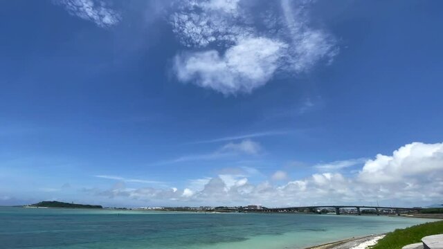 OKINAWA, JAPAN - JUNE 2021 : View of Senaga island and beach (Ocean or sea). Clear blue summer sky and clouds. Wide view time lapse shot in daytime.