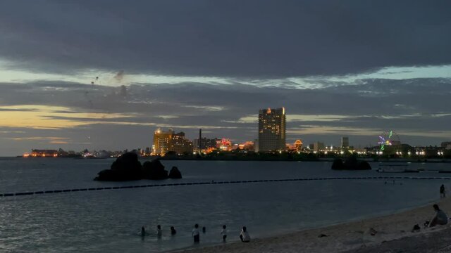 CHTAN-CHO, OKINAWA, JAPAN - JUNE 2021 : View of Araha beach (Ocean or sea) at night. Firework for cheering up the nation as it struggles with the Coronavirus (COVID-19) pandemic.