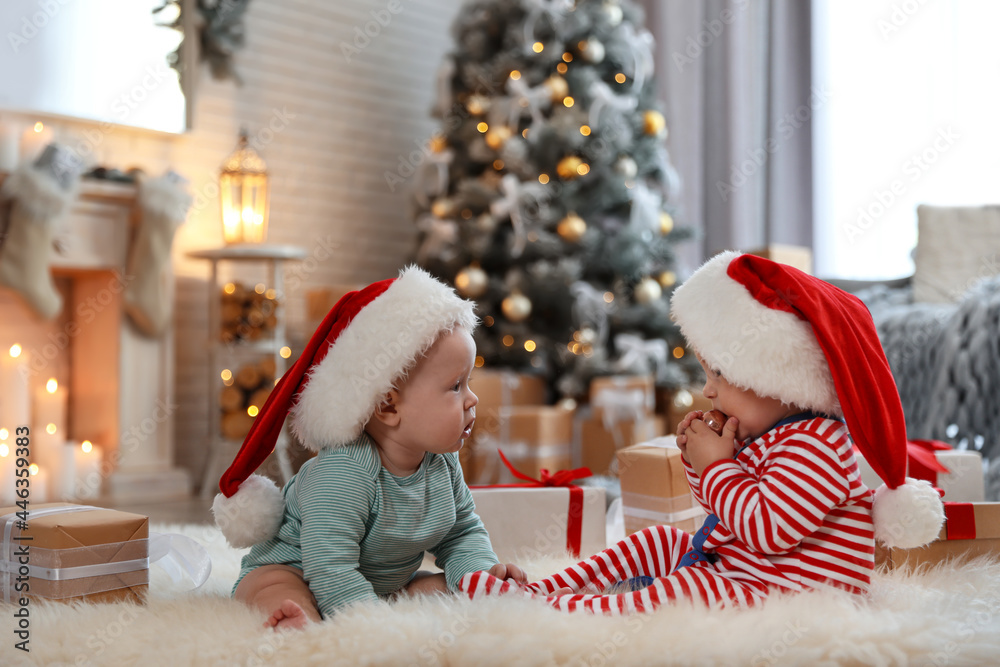 Canvas Prints Cute children in Santa hats on floor in room with Christmas tree