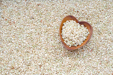 Group of dry organic rice seed pile in heart shape wooden bowl on seed background