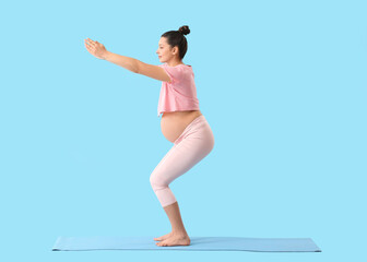Young pregnant woman practicing yoga on color background
