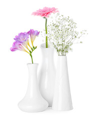Beautiful fresh flowers in vases on white background