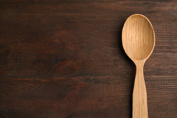 Handmade wooden spoon on rustic table, top view. Space for text